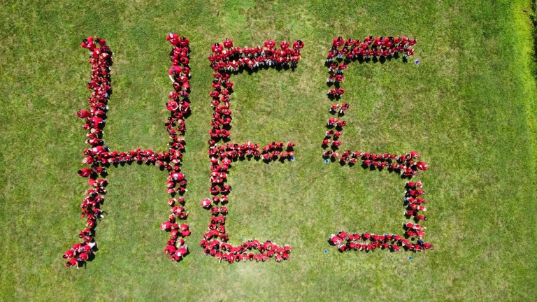 Aerial photograph of a student body forming the letters H E S