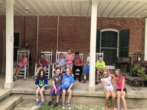 Campers on back porch of farm house.