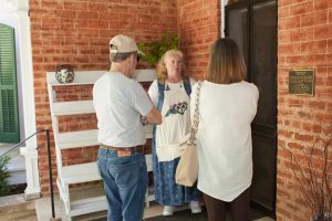 Woman in apron giving tour to two people.