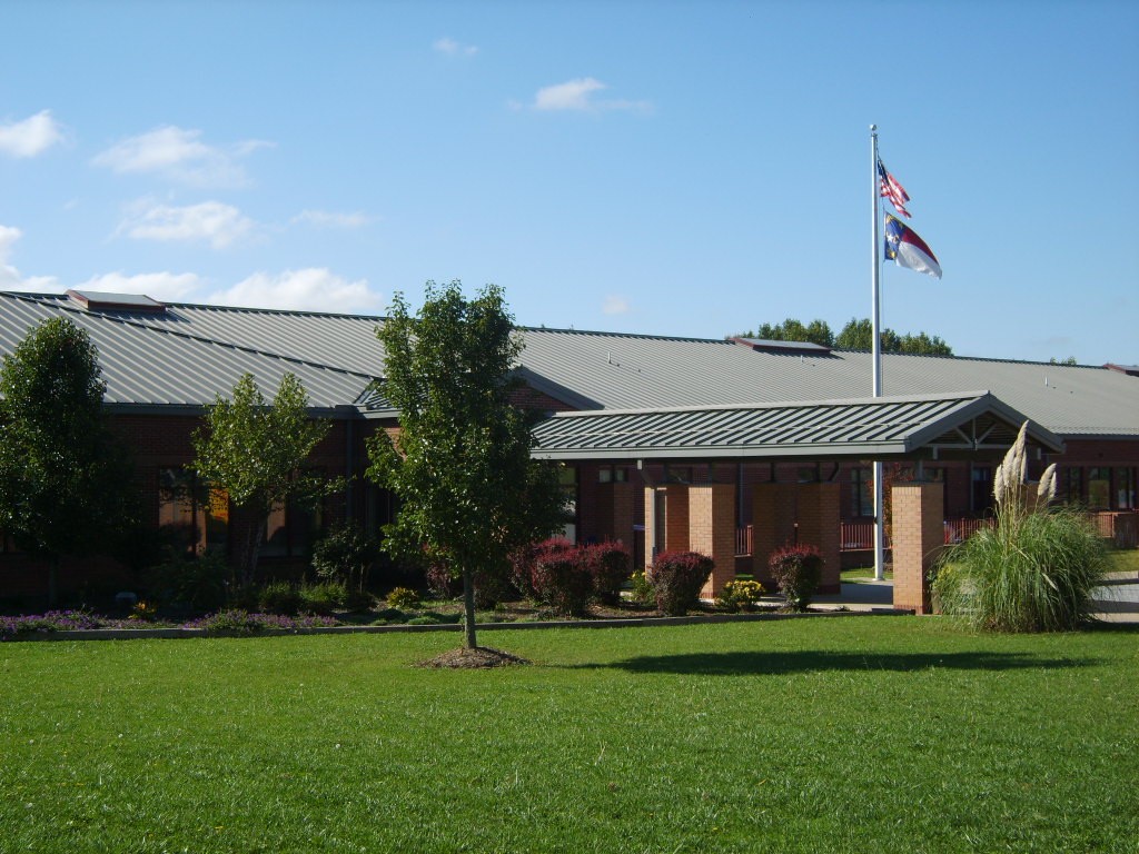 A photo of Glenn C. Marlow Elementary School from the outside. The flag pole is visible with the American flag raised.