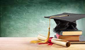 Graduation cap sitting on books beside diploma.