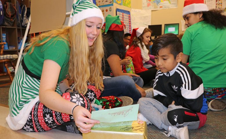 High school student opens presents with 1st-grader