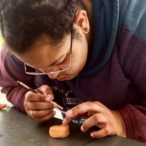 Student shapes prosthetic nose with wax.