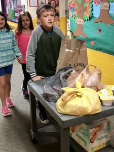 Students rolling cart with donations.