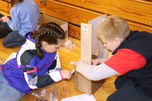 2 students building with plywood