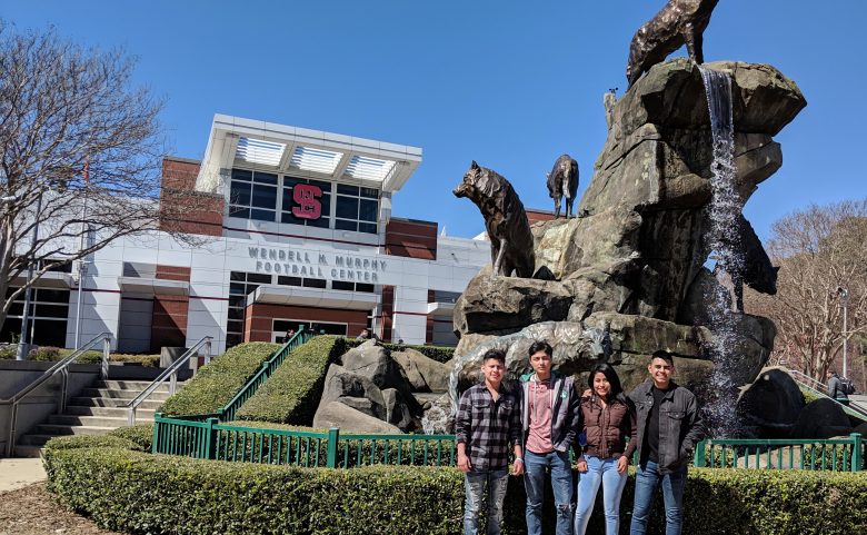 4 students in front of fountain