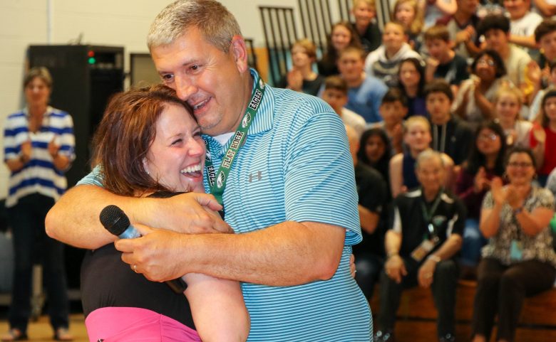 two adults hugging and smiling