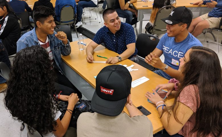 6 people at table, smiling