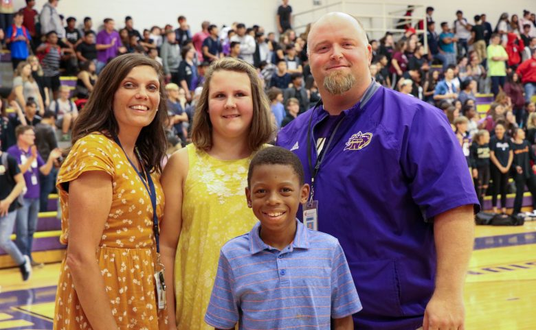 family of four smiling in gym