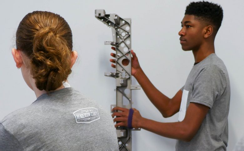 student touching metal object