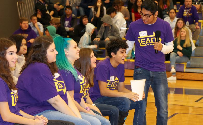 6 students sitting together in crowded gym