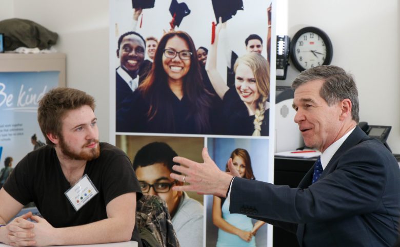 Governor gesturing towards student