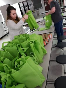 2 volunteers packing bags of food