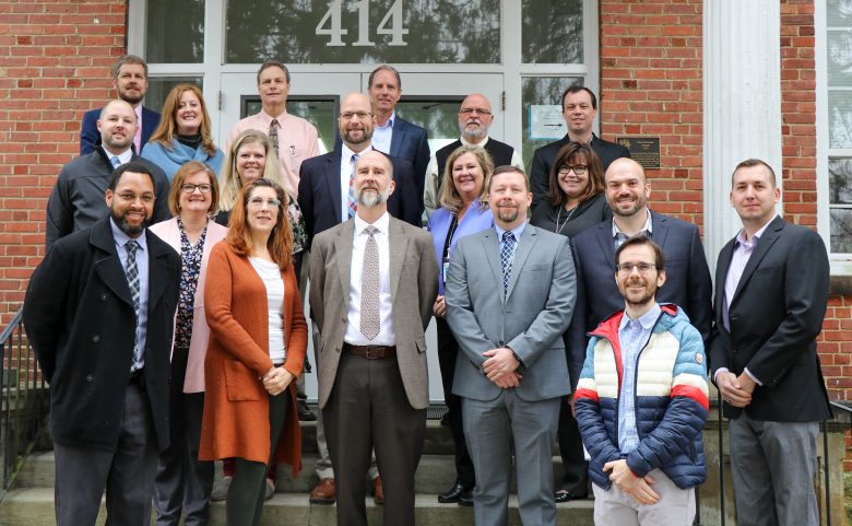 group of 19 adults on building front steps