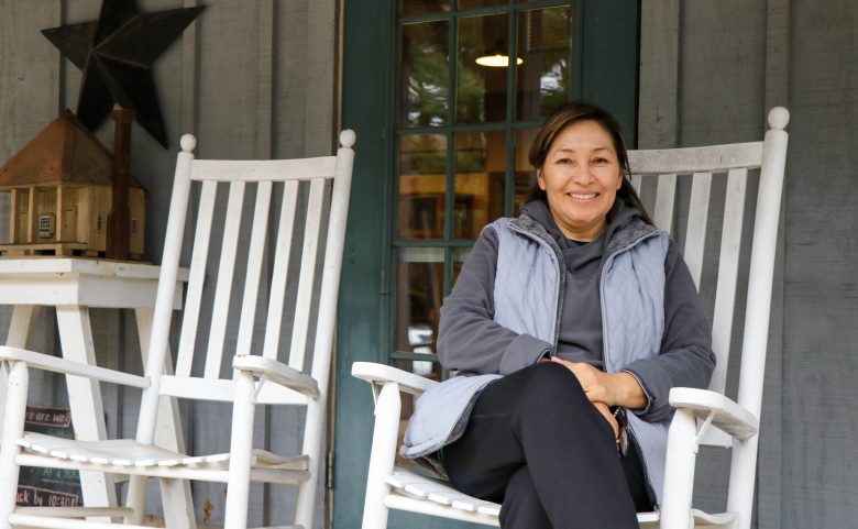 woman on rocking chair in front of house