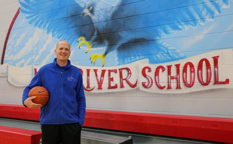 coach holding basketball in gym