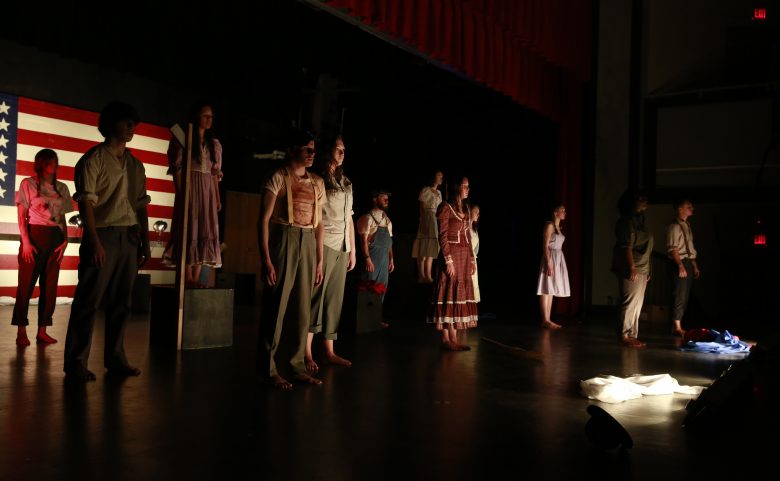 12 high school students on dark stage