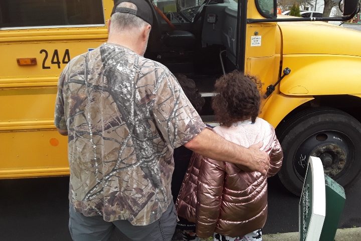 man and child approaching school bus