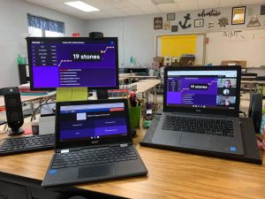 desk with two laptops and desktop