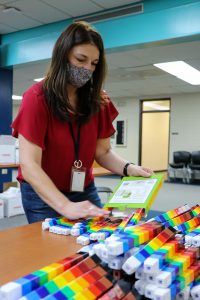 woman in mask organizing Unifix cubes