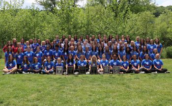 group of middle school girl athletes gathered outside in group picture