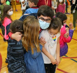 teacher getting a group hug from 4 students