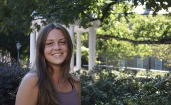 young woman standing outside, smiling