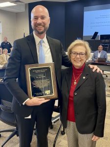 Dr. Bryant and mayor holding award in board room