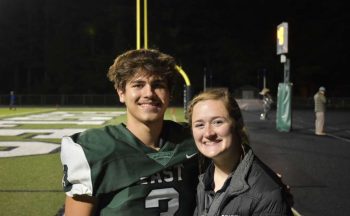 student and athletic trainer on football field