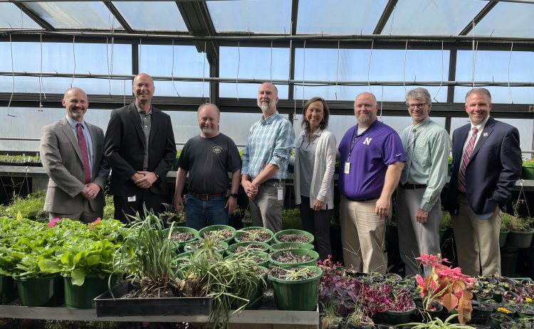 8 people standing in greenhouse