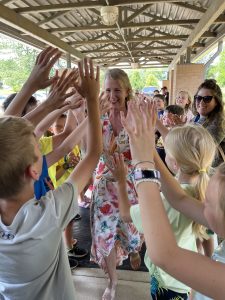 woman walking through students high-fiving her