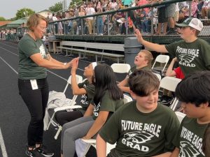 principal high-fiving students in "future eagle grad" t-shirts