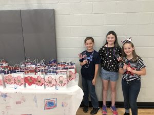 Students holding flags and gifts for veterans