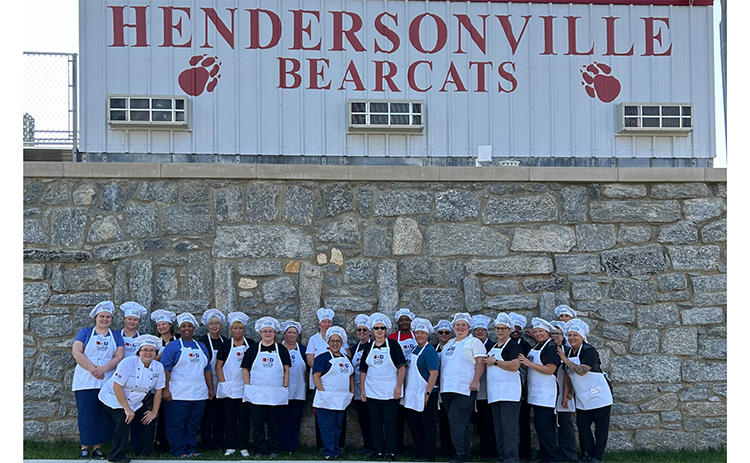 Culinary students in front of Hendersonville High School sign.
