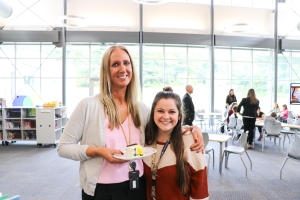 Ms. Schneider posing for a photo with her teacher assistant in the library. 