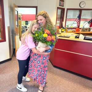 Carrie Cheek's daughter gives her a big hug after the announcement. 