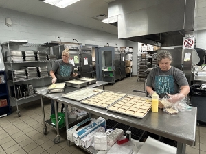 Ms. Staci and Ms. Kristine prepping mashed potatoes and grilled cheeses.