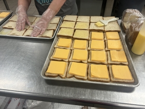 Open grilled cheeses on a pan in the kitchen.