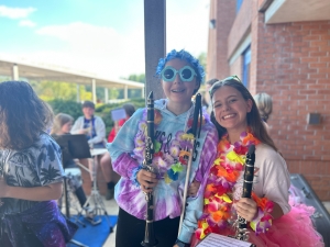 Two band students with clarinets and hawaian gear on. 